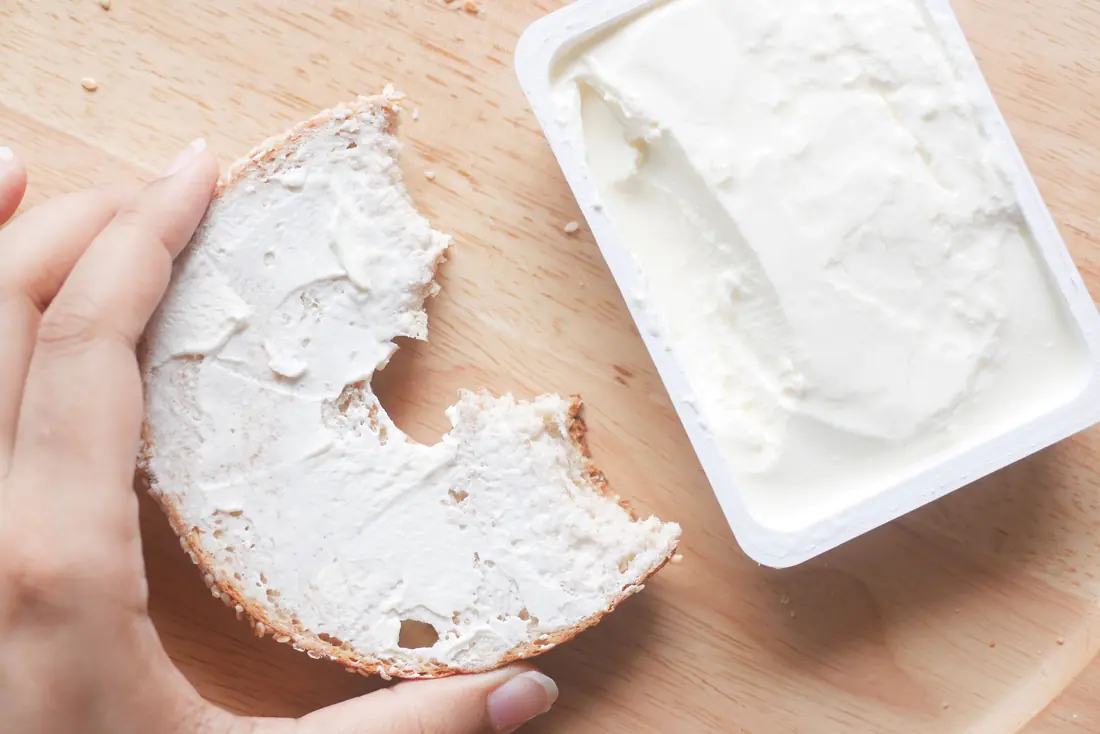 A bagel spread with soft cheese