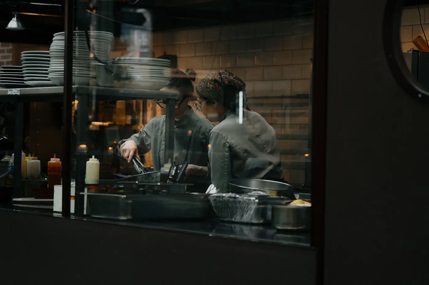 Cooks working behind a kitchen pass