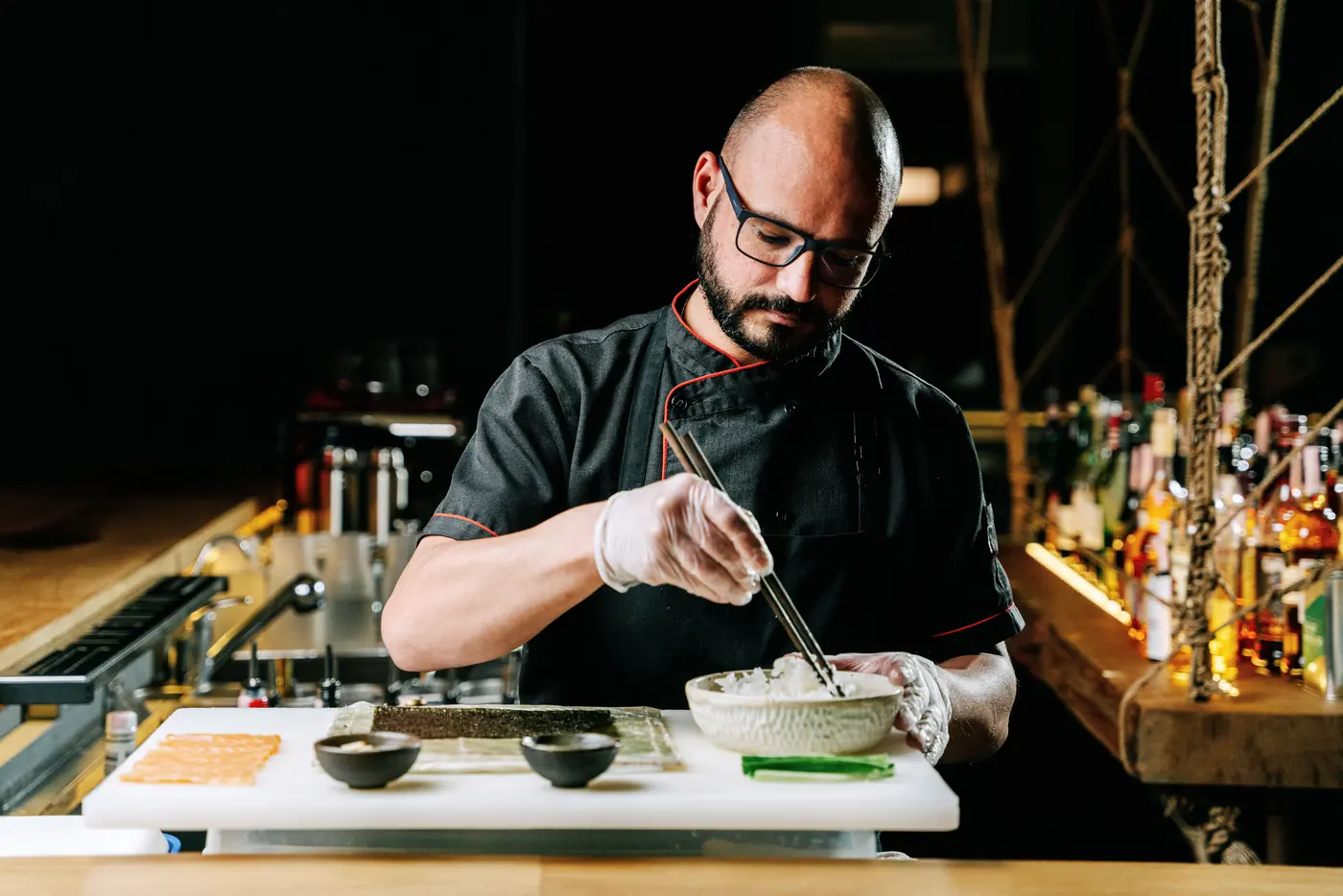 A chef finishing a dish at a counter