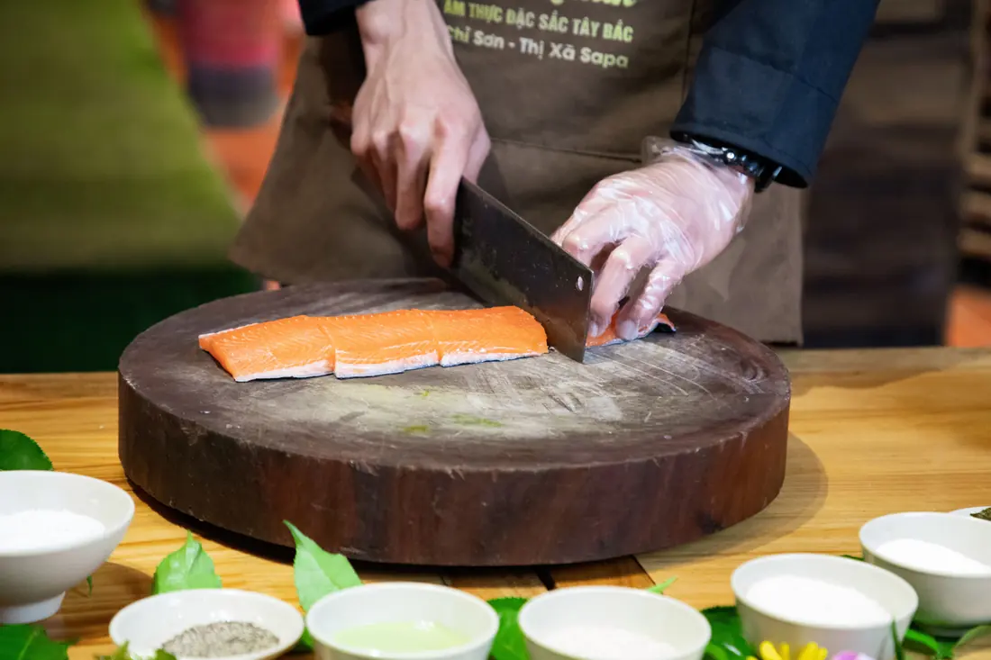 A cook slicing a salmon fillet