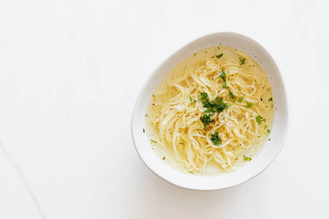 A clear broth with noodles