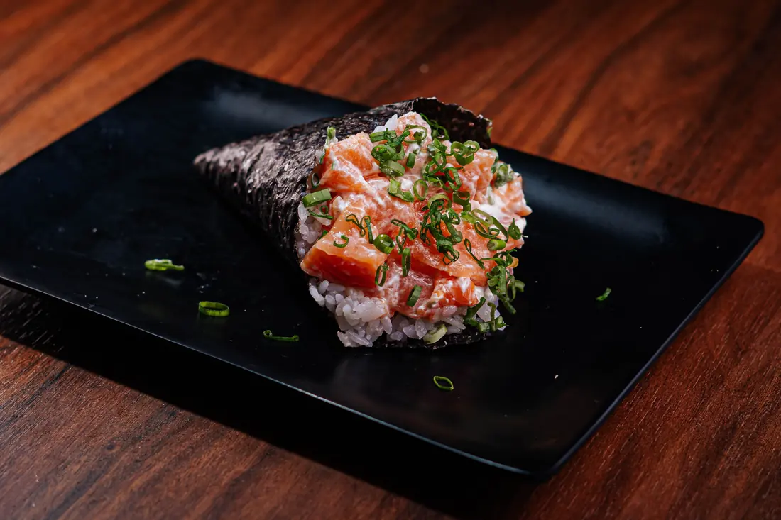 A hand roll wrapped in dark seaweed