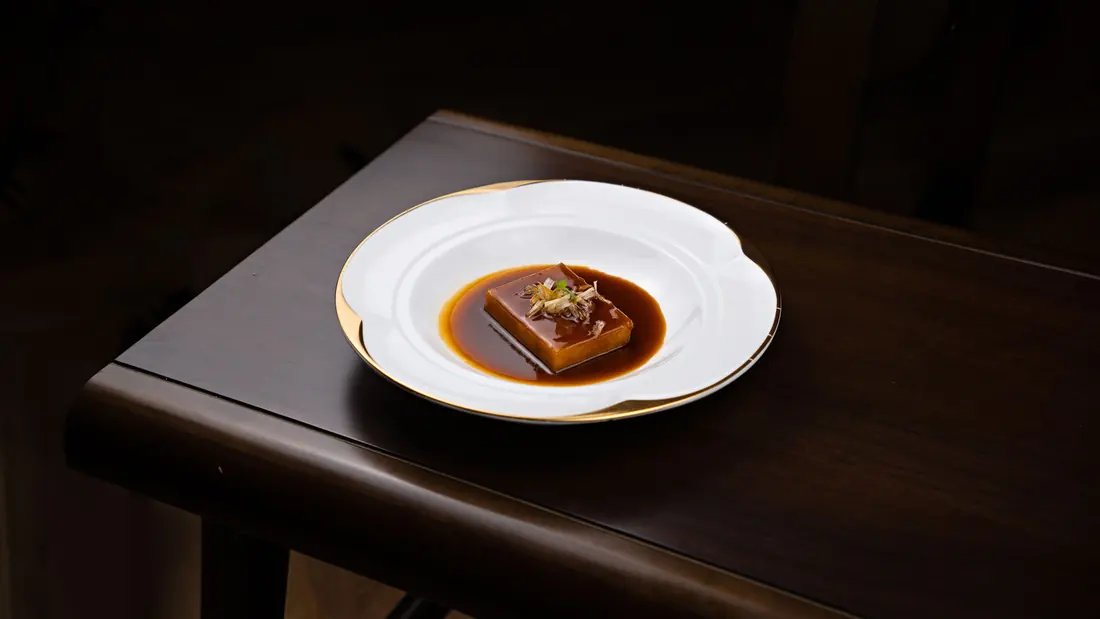 A dark sauce pooled on a plate