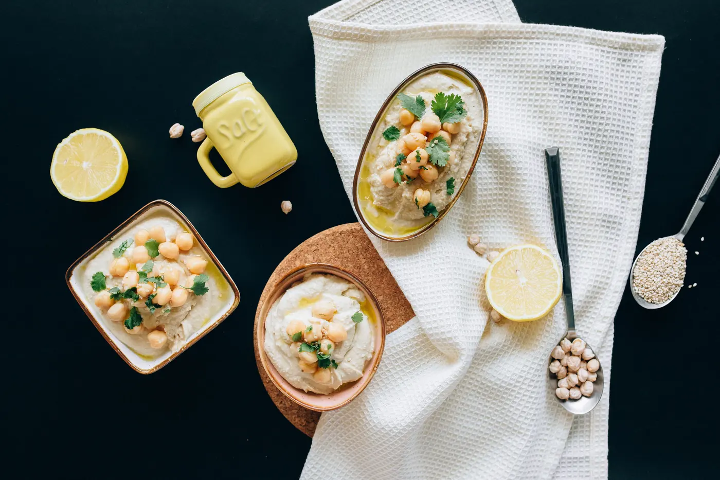 Bowls of a pale thick dip with chickpeas
