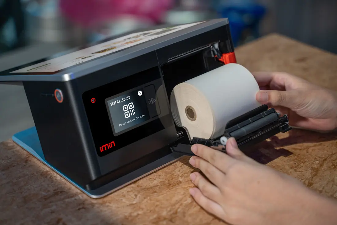 A receipt printer being loaded with paper