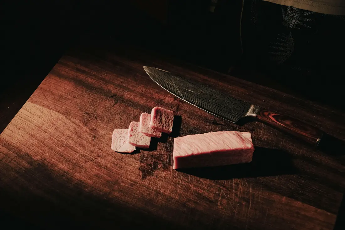 A long knife beside sliced fish