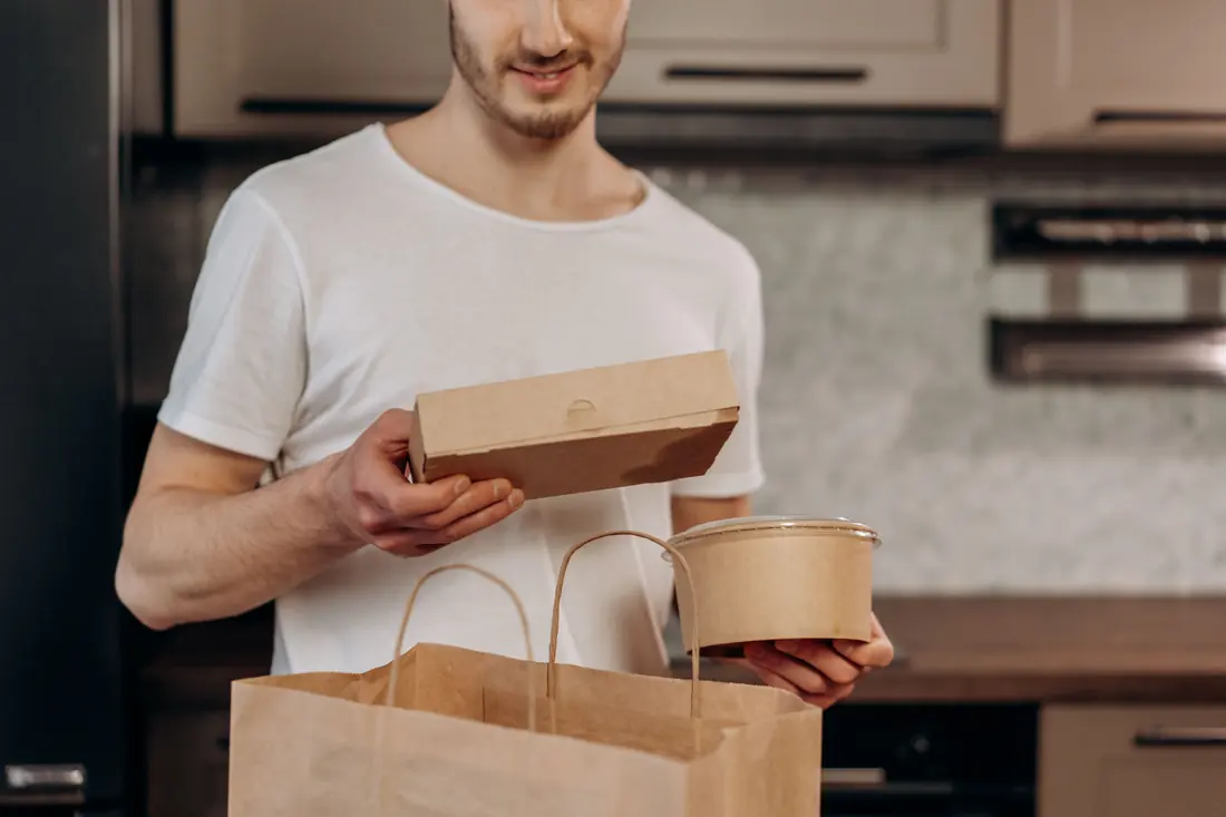 A paper bag of takeaway containers