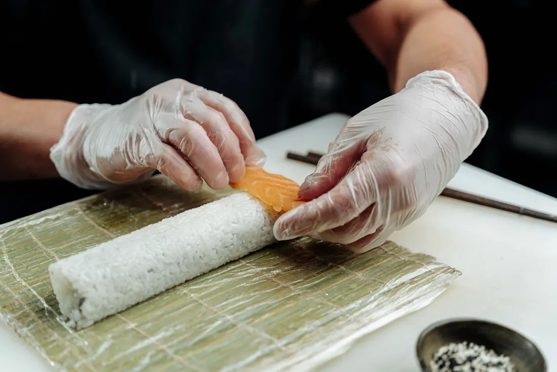 A roll being wrapped on a bamboo mat