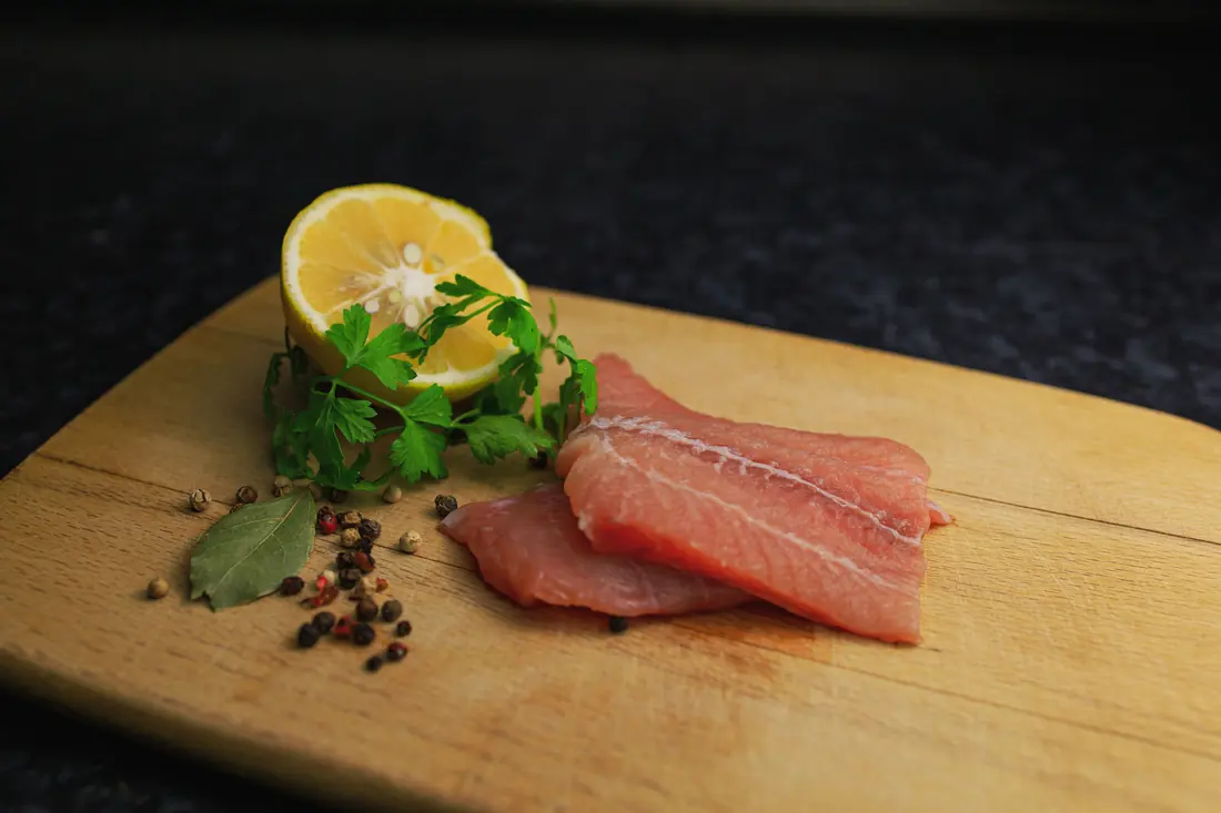 A raw fish fillet on a board