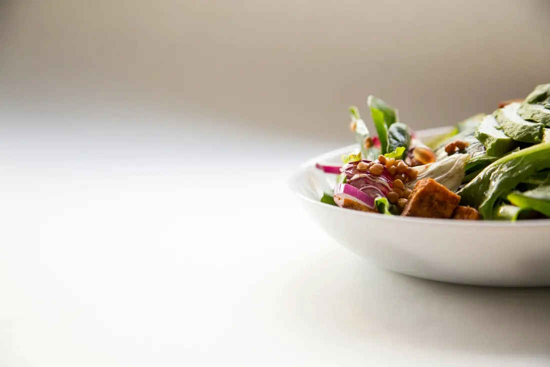 A mixed salad in a white bowl