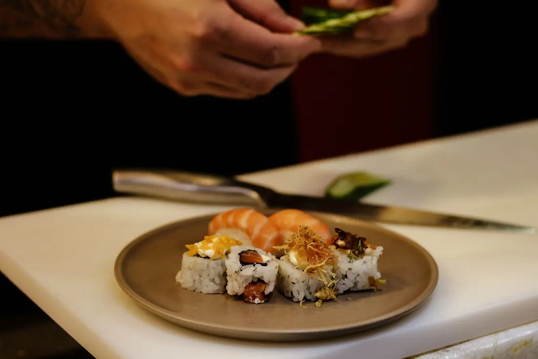 Cut rolls topped with fish on a plate