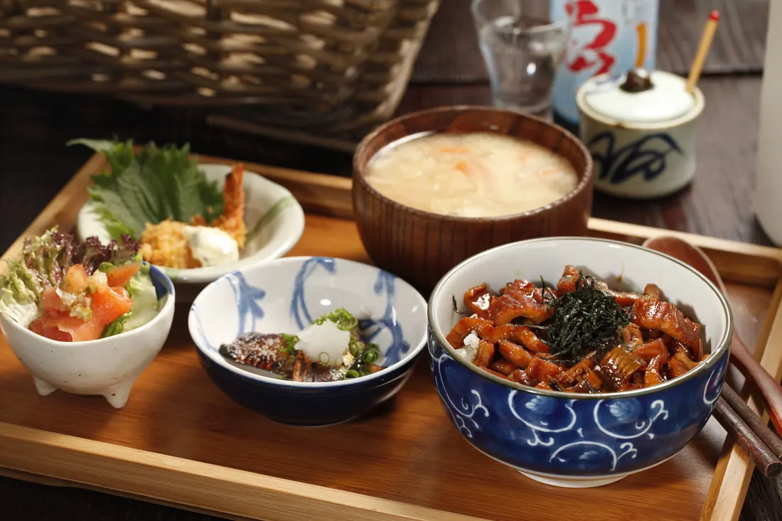 A meal tray of rice, soup and small side dishes