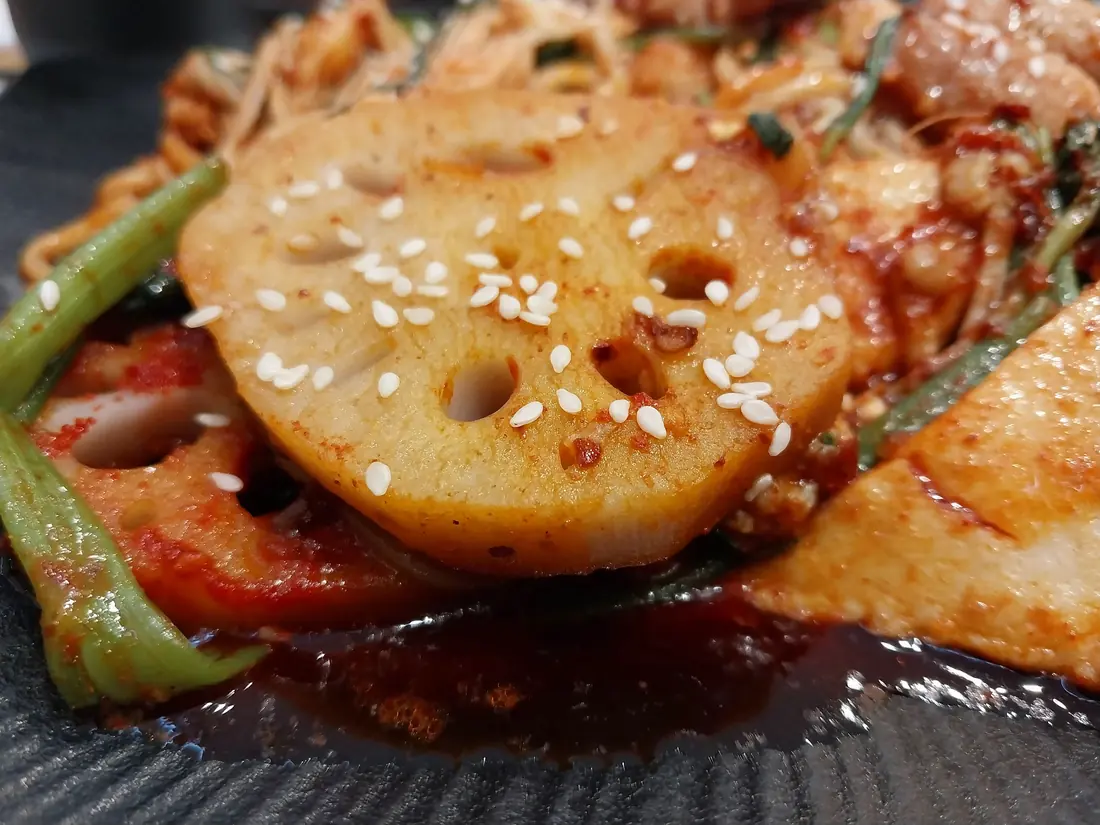 A lotus root slice in a cooked dish