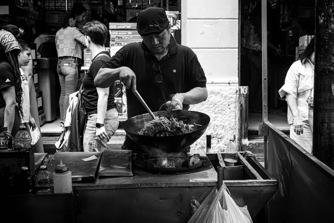 A street cook working a wok over high heat