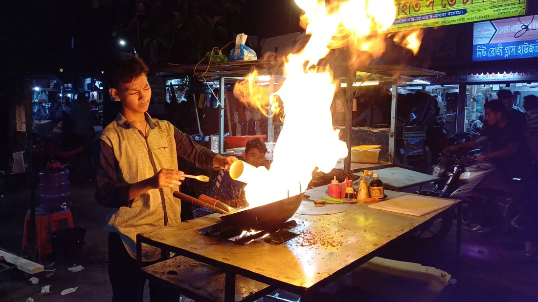 A cook working over a high flame