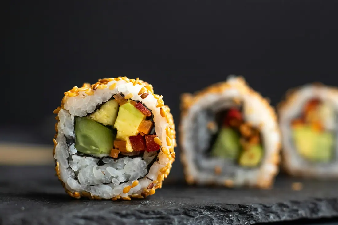 Thinly fanned avocado laid over a sushi roll