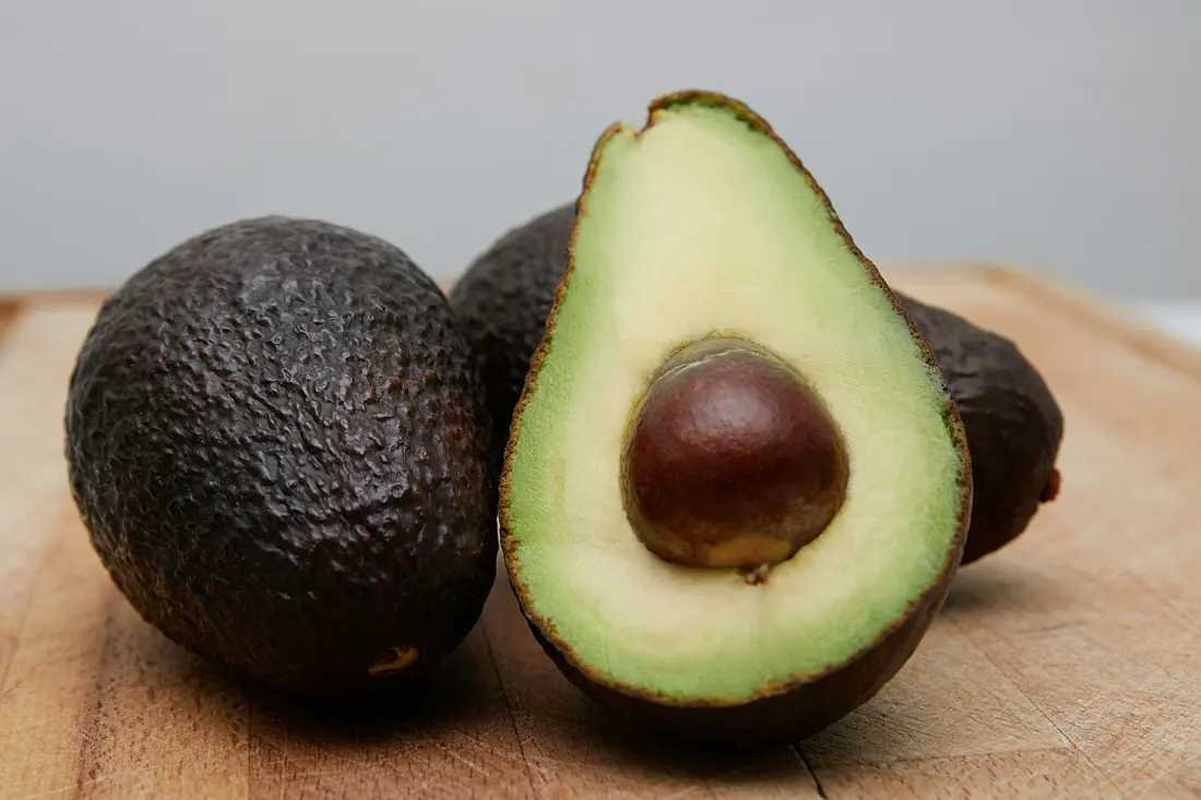 Ripe avocados, one cut in half