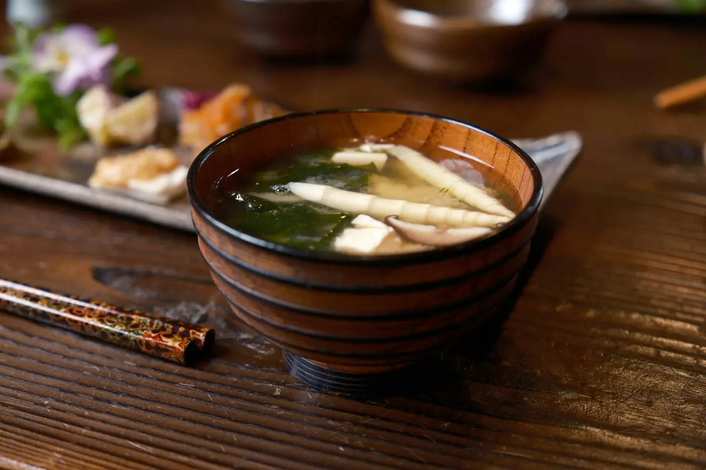 A bowl of miso soup with tofu and seaweed