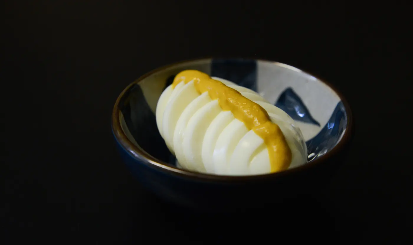 Yellow mustard beside a boiled egg