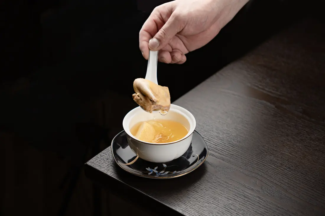 Broth being lifted in a spoon