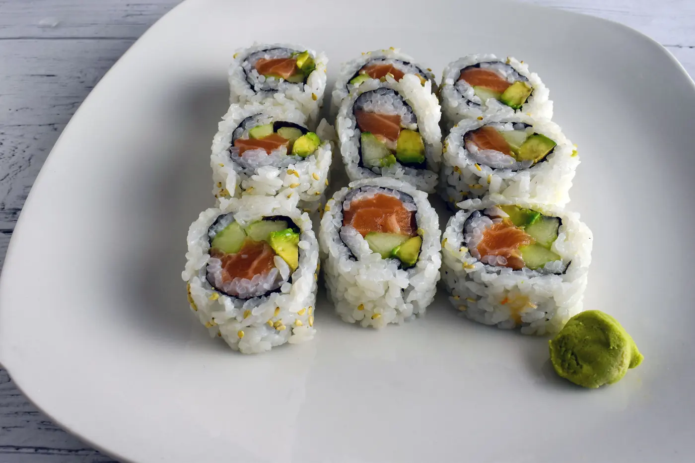 Cut sushi rolls arranged on a white plate