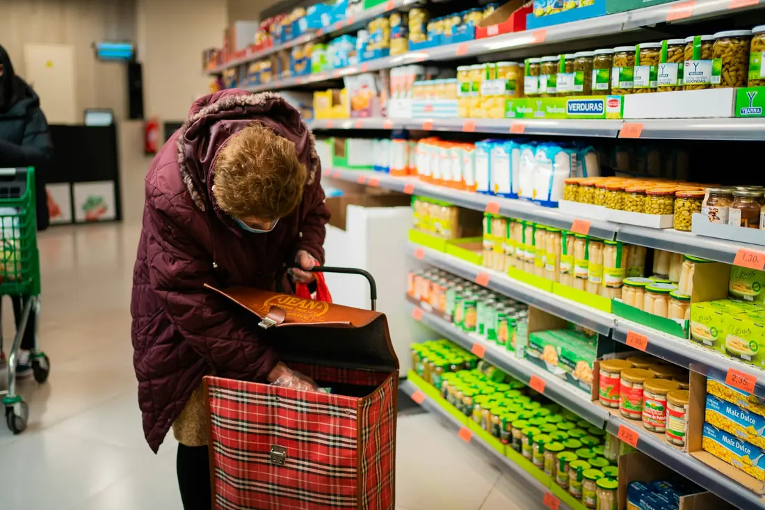 A shopper choosing items in a grocery aisle