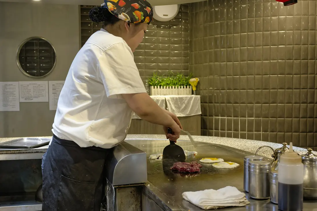 A chef cooking on a flat teppan grill