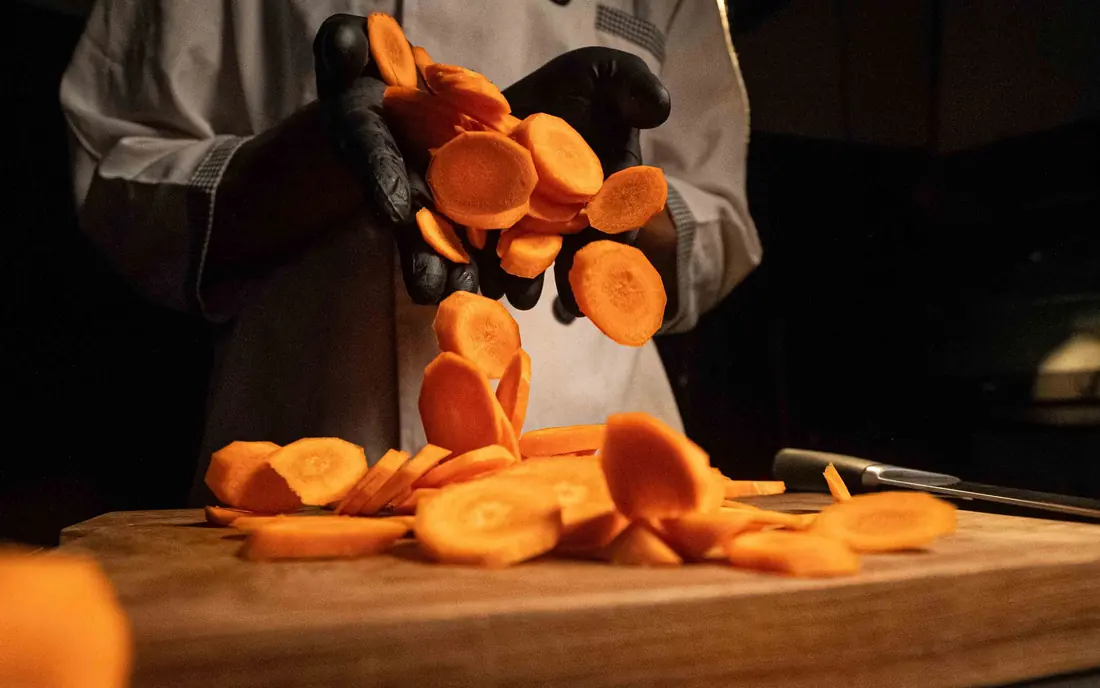 Sliced carrots lifted from a board