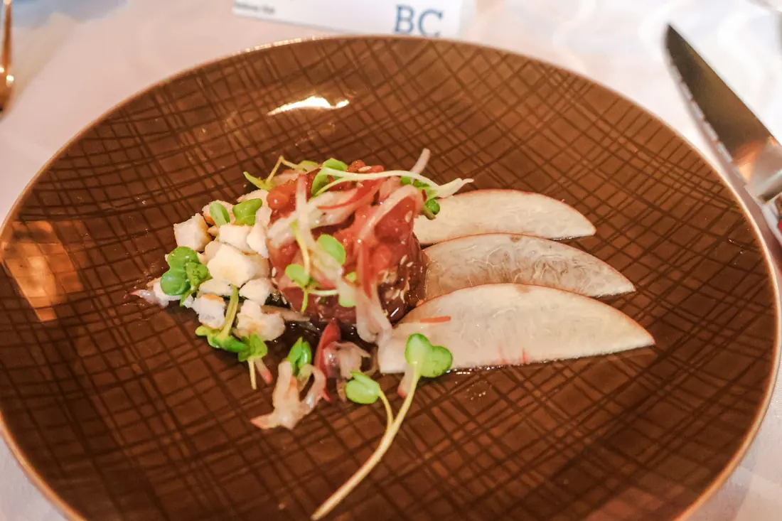 A plate of raw fish with a light garnish