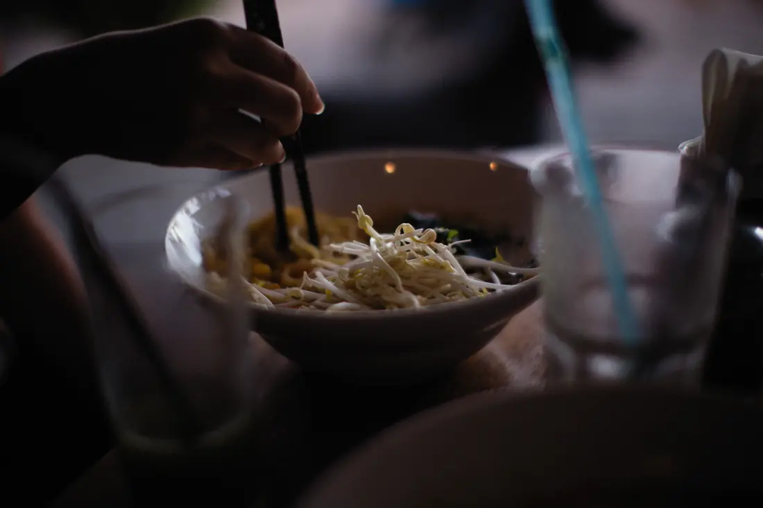 Eating from a bowl with chopsticks