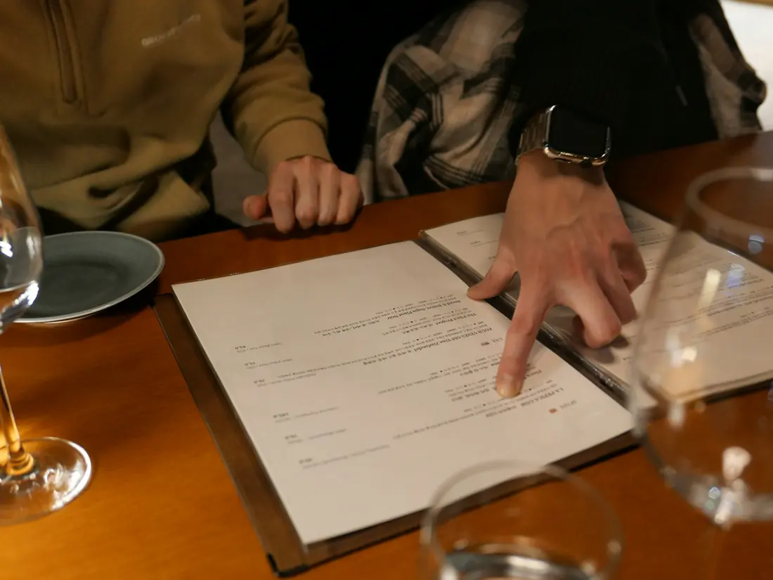 A diner reading a menu at a restaurant table