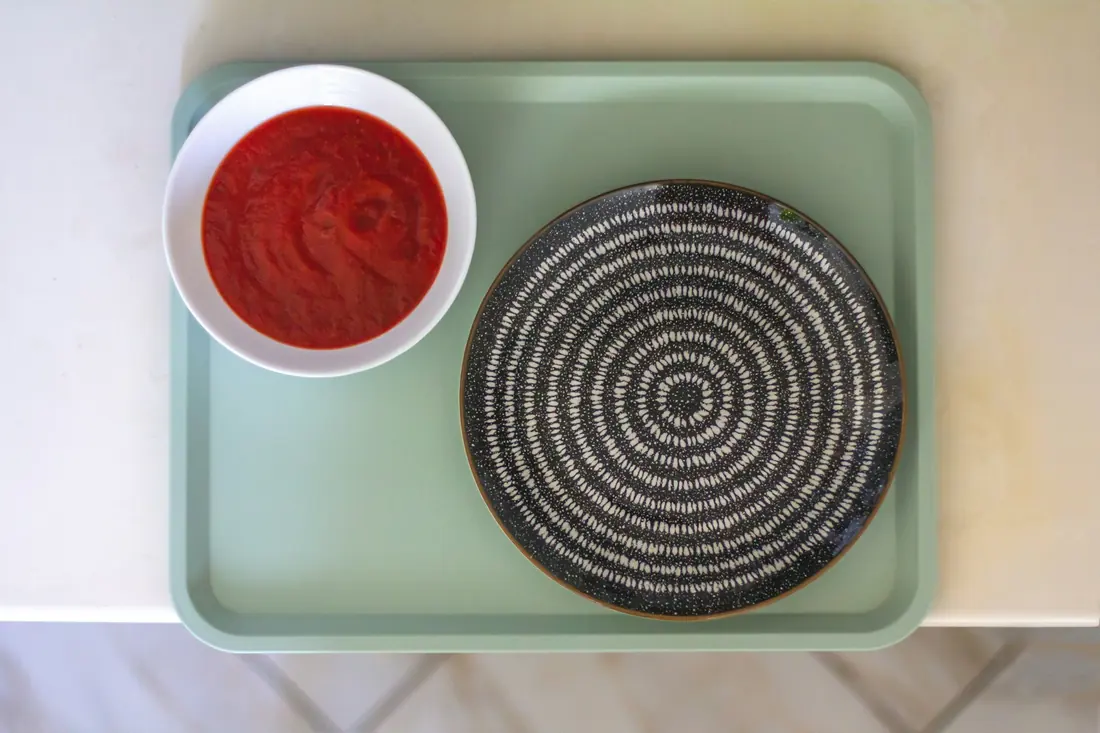 A small bowl of red dipping sauce on a tray