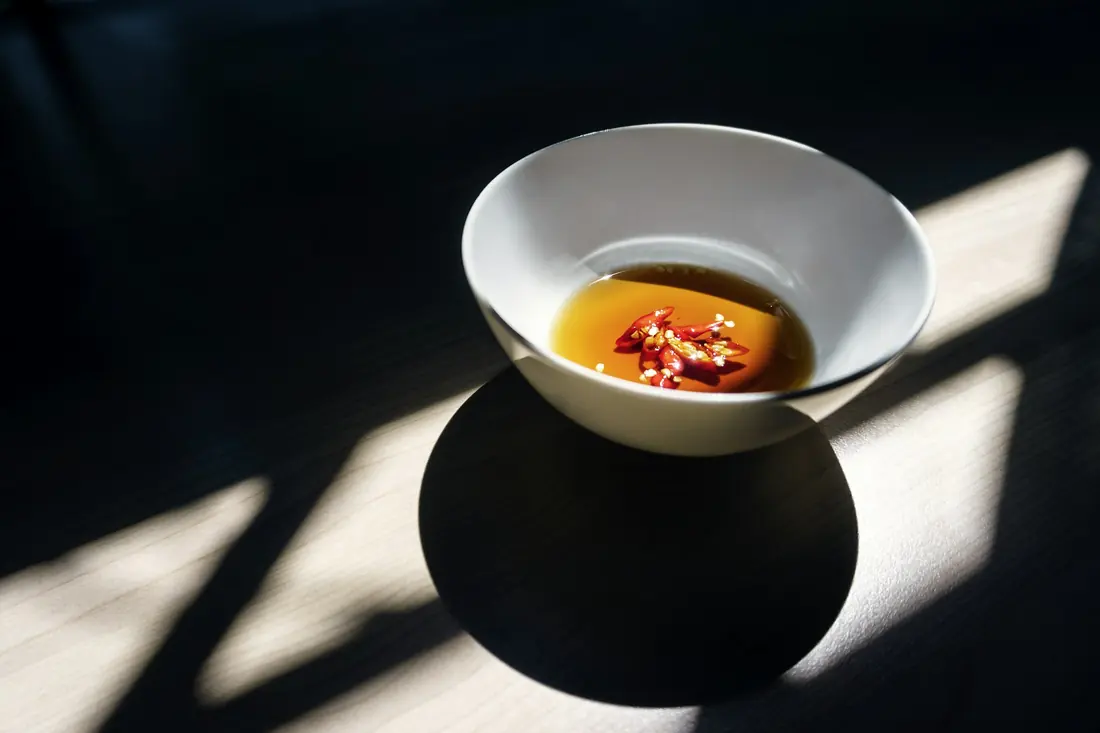 A dipping sauce with chilli and herbs in it