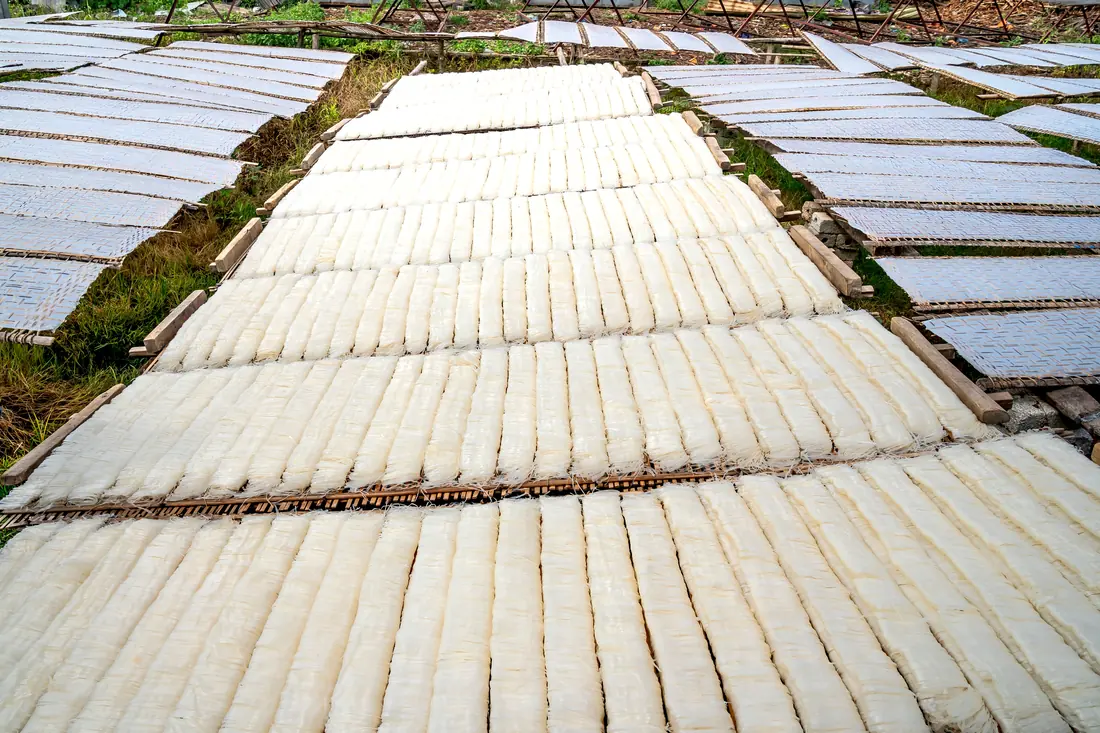 Rice noodle sheets drying on racks