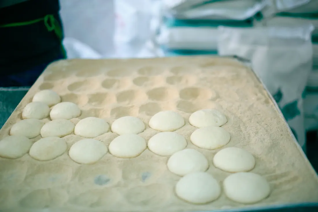 Small pale dough discs on a tray