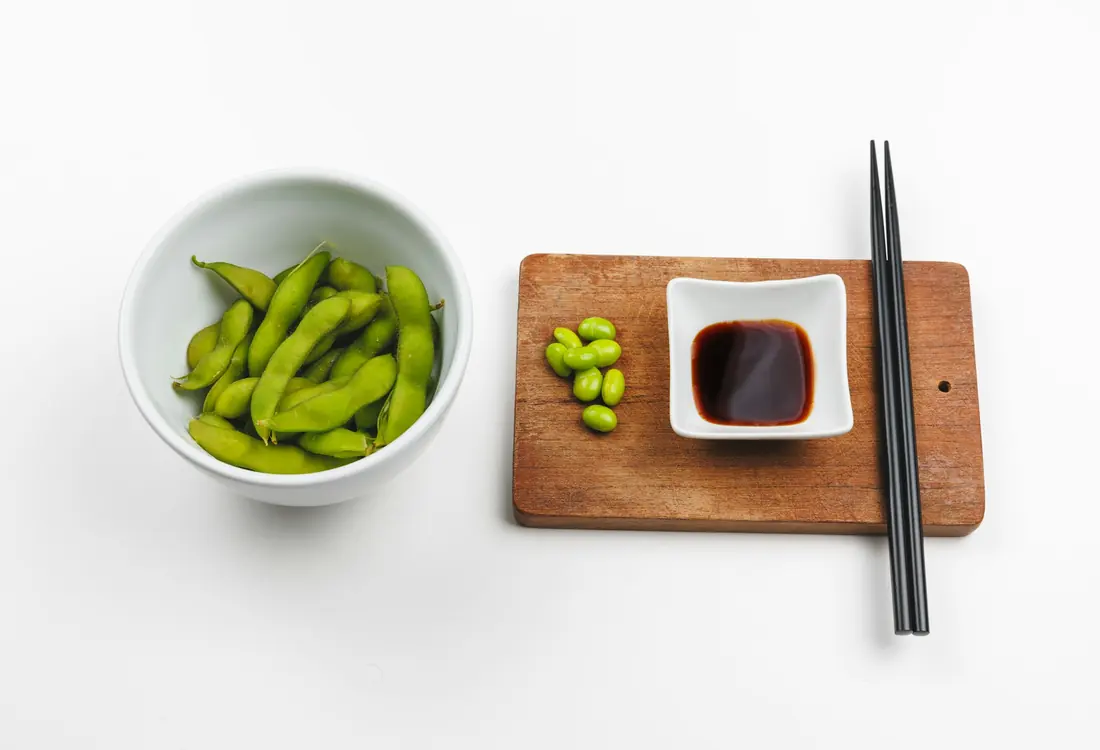 A bowl of edamame set out with chopsticks