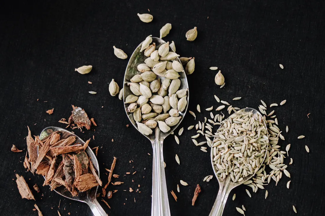 Spoons of three different whole spices