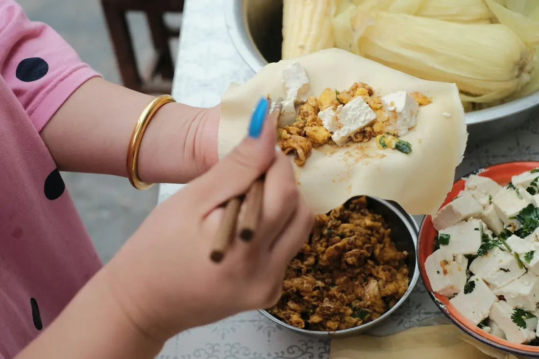 Filling being spooned onto a wrapper before folding