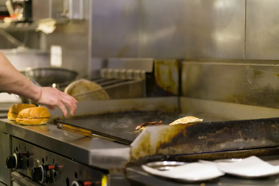A flat-top griddle in use in a restaurant kitchen