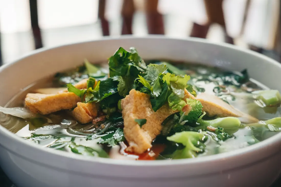 Greens and tofu floating in a broth