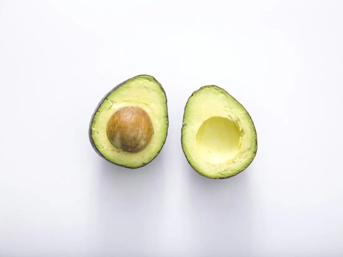 A halved avocado with the stone still in place