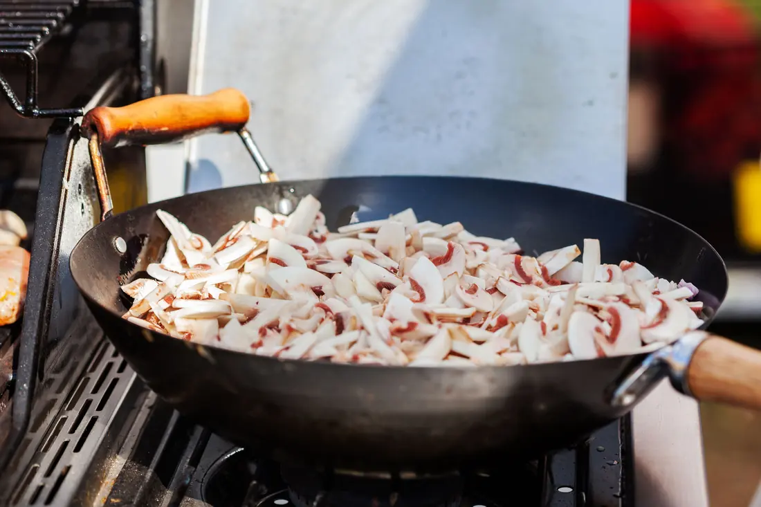 Sliced mushrooms cooking in a wok