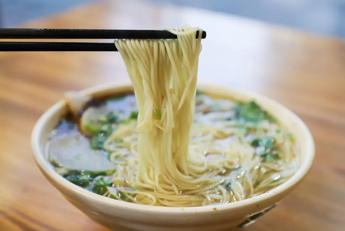 Wheat noodles lifted from a bowl