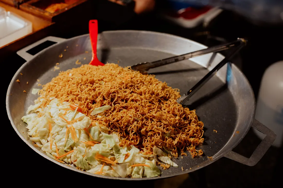 Noodles being stirred in a wok