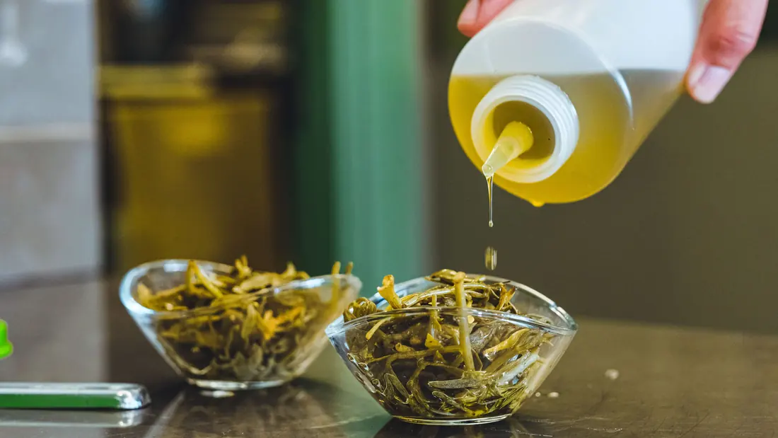 Oil being squeezed over dressed vegetables