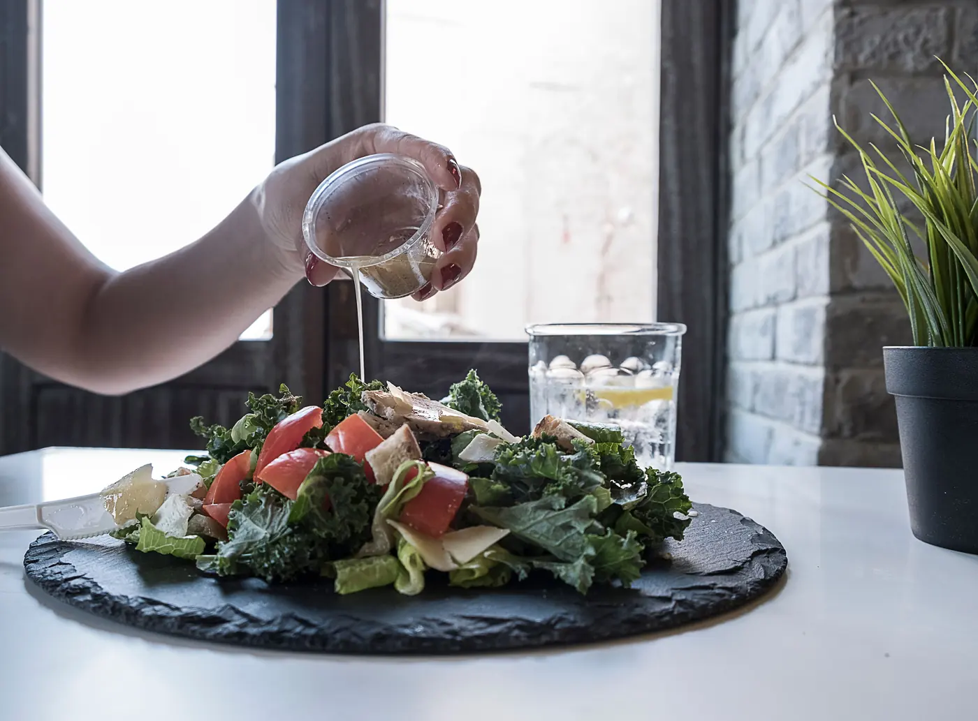 Dressing being poured over a salad