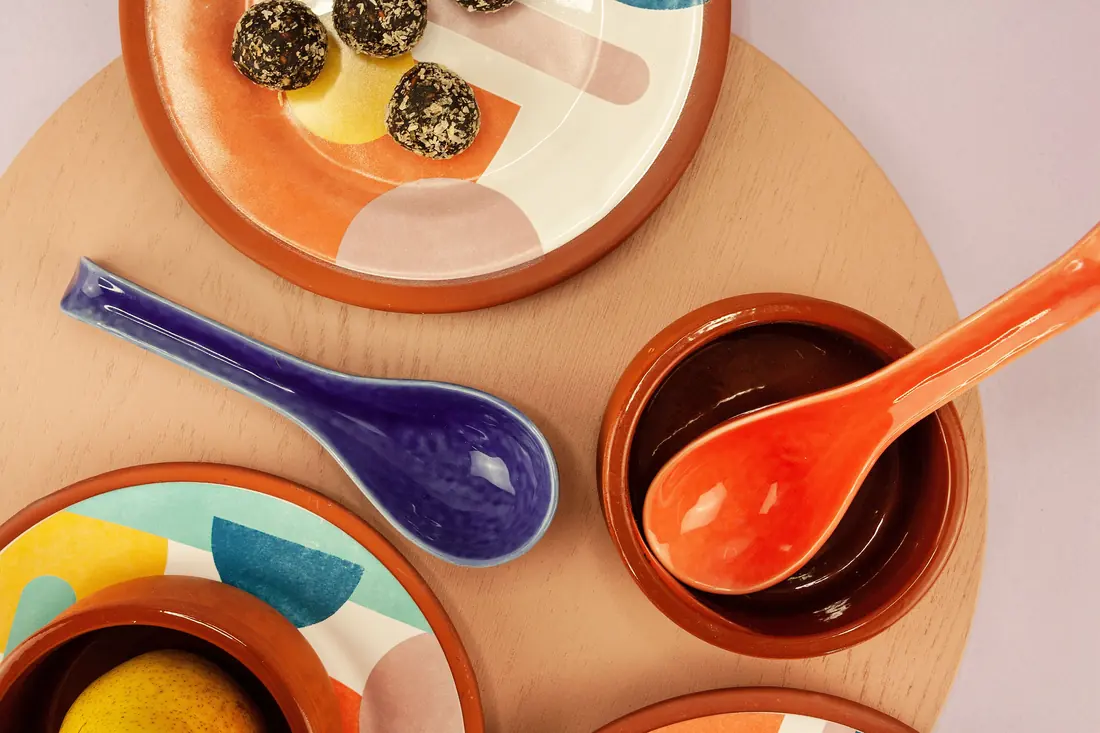 Coloured ceramic spoons on plates