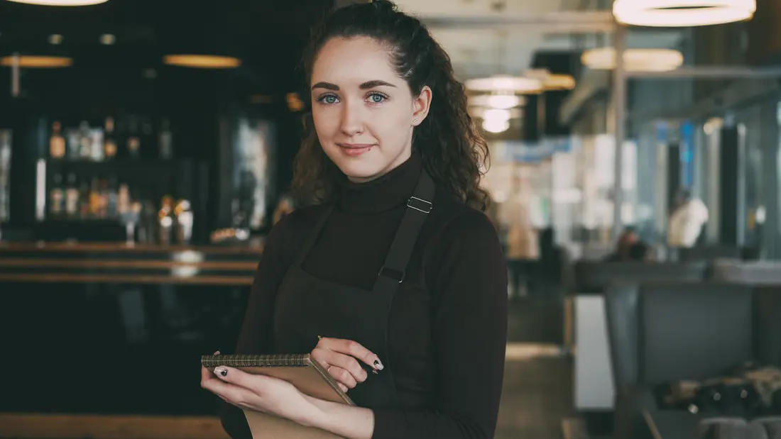 A member of staff taking a call inside a restaurant