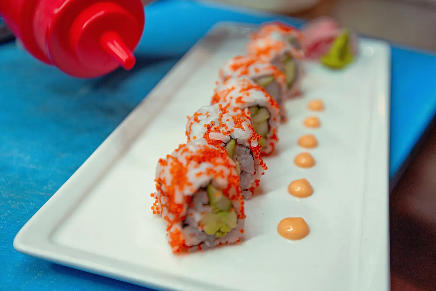 A pale pink sauce drizzled over sushi