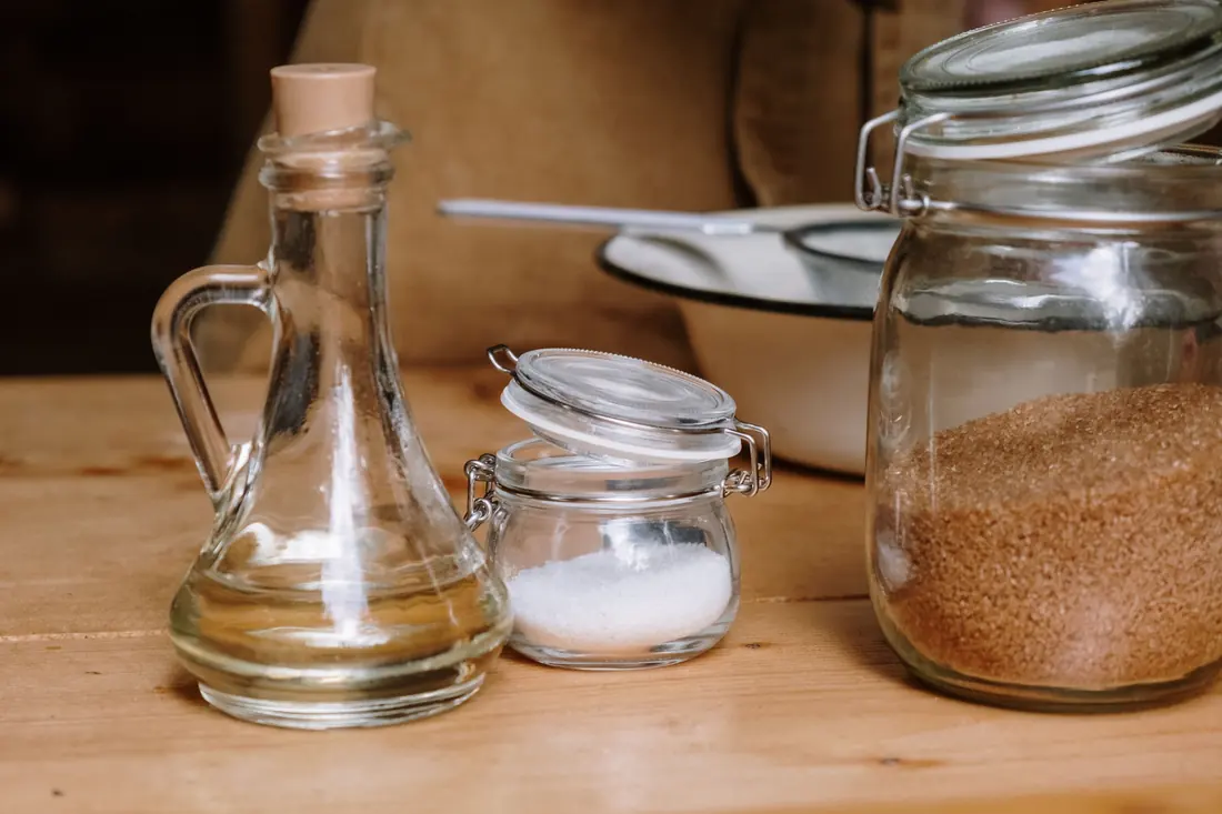 Oil, salt and sugar in jars on a counter